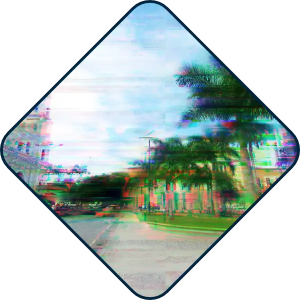 Una escena callejera con palmeras y un edificio, vista a través de una ventana en forma de diamante con un efecto de falla en la imagen, que recuerda a una campaña publicitaria de una agencia de marketing digital en Bucaramanga.